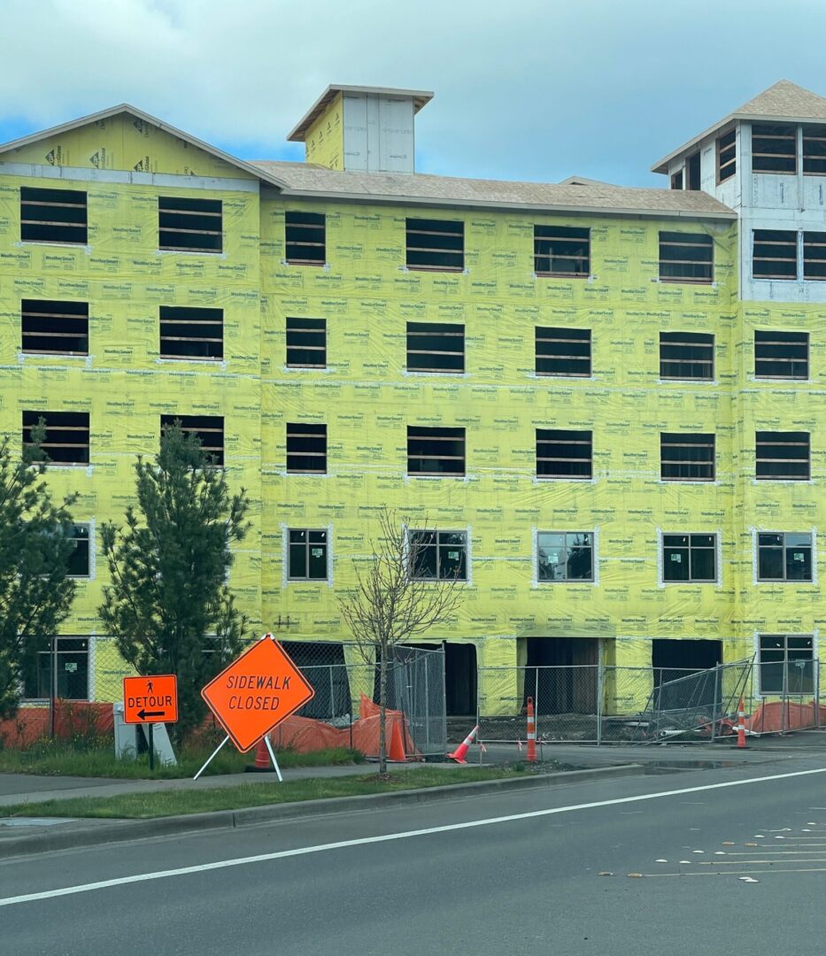 A building with yellow walls and orange construction signs.